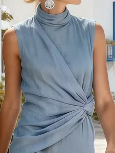Gros plan sur le col montant drapé sans manches et le nœud torsadé à la taille de la robe.