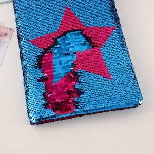 Detailed close-up of reversible sequin notebook cover with sparkling star pattern texture.