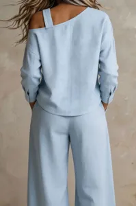 Detail view of light blue women casual two piece outfit featuring one shoulder top and pants.
