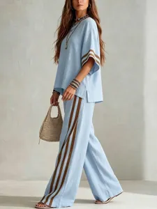 Casual linen two-piece set detail showing light blue top and wide-leg trousers with brown stripes.