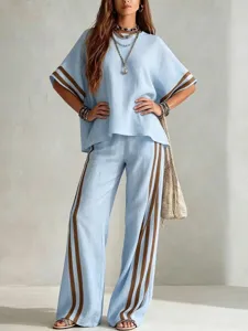 Light blue linen two piece resort wear set featuring short sleeve top and wide leg pants.