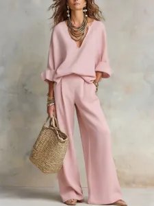 Elegant pink loose-fitting casual pantsuit set with stylish straw bag and layered accessories.