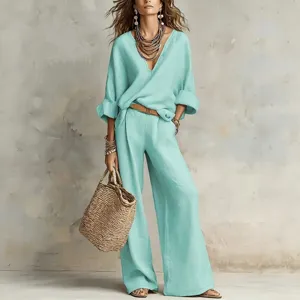 Detail shot of elegant turquoise casual two-piece outfit with wide-leg pants and accessories.