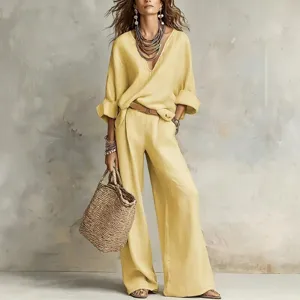 Detailed view of loose linen blend V-neck top and wide leg pants set in yellow, resort style.