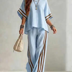 Chic light blue two-piece linen outfit with brown side stripes, casual resort wear for women.
