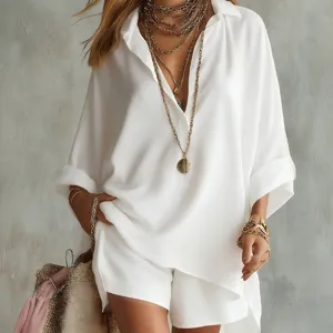 Summer white loose shirt and shorts set with layered gold necklaces and chic handbag.