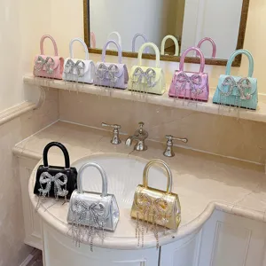 Detailansicht der eleganten kleinen Handtasche mit funkelnder Kristallschleife und Ketten.