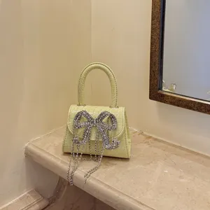 Nahaufnahme der funkelnden Strassschleife und Kristallquasten an der eleganten Mini-Handtasche.