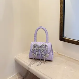 Lavendelfarbene Mini-Handtasche mit Strass-Schleife und Quasten, elegante Abendtasche.