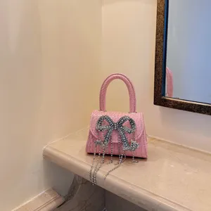 Rosa Krokodil-Textur Mini-Handtasche mit funkelnder Strass-Schleife und eleganten Fransen-Details.