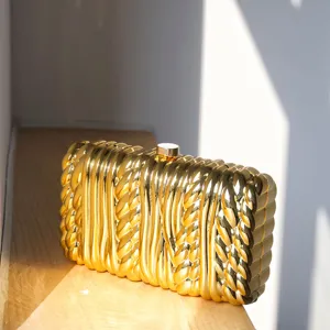 Gold metallic twisted texture hard shell clutch bag, elegant minimalist evening bag detail.