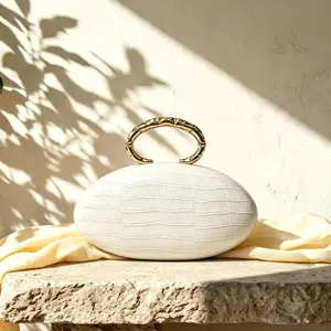 White PU crocodile texture oval clutch bag with gold metallic loop handle for elegant evening.