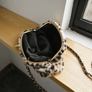 Detailansicht einer flauschigen Leo-Muster Kussverschluss Handtasche mit goldener Kette.