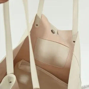 Interior view of a minimalist large capacity beige tote bag with inner pocket and zipper.