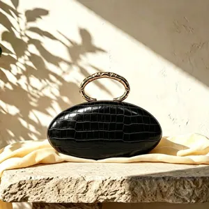 Elegant black crocodile PU leather oval clutch bag featuring unique gold metal ring handle.