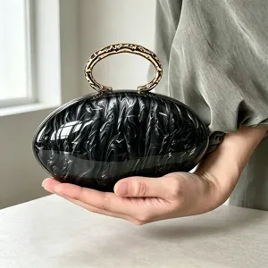 Elegante bolso de mano ovalado con efecto mármol francés y asa de anillo metálico para fiestas.