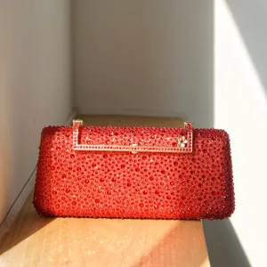 Red rhinestone evening clutch bag with gold hardware, elegant sparkling formal purse detail.