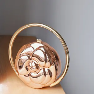 Elegant rose gold metallic camellia embossed spherical handbag with round ring handle.