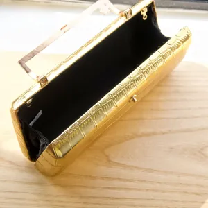 Gold evening clutch bag detail showing metallic frame texture and black interior lining structure