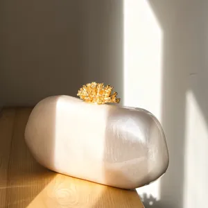 Unregelmäßige ovale Abendtasche mit vergoldetem Korallenverschluss und Perlmuttglanz für Damen.