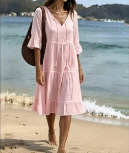 Detailed view of a pink tiered beach dress with V-neck and tassels for summer vacations.