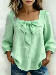 Blouse verte avec nœud et col carré, mettant en valeur de superbes détails élégants et féminins.