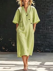 Robe midi décontractée à col V, manches courtes, poches latérales et détails de boutons.