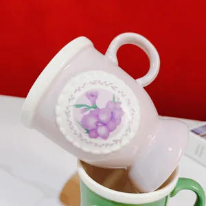 Detailed view of vintage high-stem ceramic mug with pink floral lace pattern and handle.