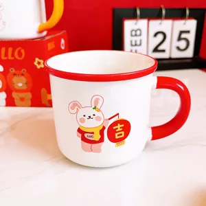 Jolie tasse à café en céramique avec motif de lapin mignon, anse et bord rouges pour enfants.
