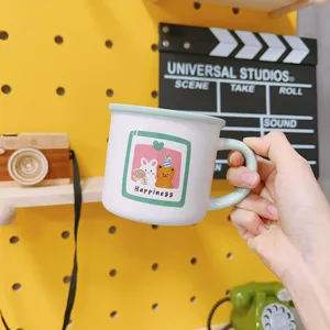 Cute cartoon ceramic mug with rabbit and bear illustration for coffee and breakfast use.