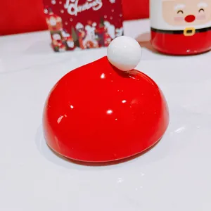 Ceramic Christmas santa hat mug lid in vibrant red and white, cute festive tabletop detail.