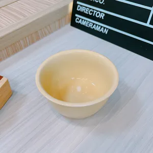 Close-up detail of a pastel yellow ceramic bowl, perfect for solo dining and cute table decor.