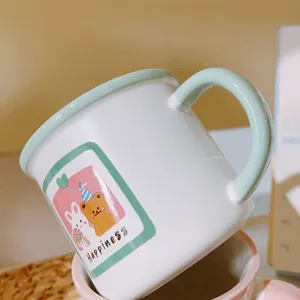 Cute ceramic coffee mug with green handle and lovely bear rabbit cartoon print for daily use.