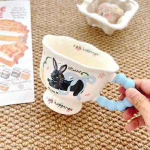 Cute ceramic mug detail showing rabbit print and unique blue bubble handle design.