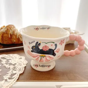 Detail shot of cute ceramic mug with pink bubble handle and lovely black rabbit pattern.