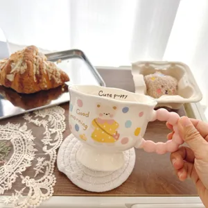Cute ceramic coffee mug with sweet bear print and pink ball handle for daily use.