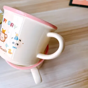 Cute ceramic coffee mug with pink rim and cartoon animal prints for kids and breakfast.
