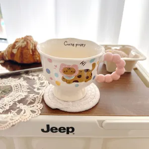 Detailed view of ceramic coffee mug featuring cute puppy print and unique pink bubble handle.