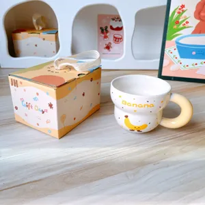Taza de cafe de ceramica bonita con patron de dibujo animado de platano y caja de regalo