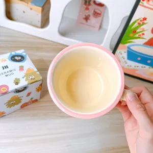 Detailed close-up view of a charming ceramic mug featuring a lovely pink rim and yellow.