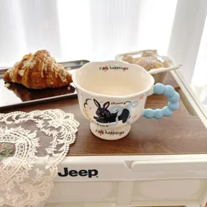 Detailed view of the cute ceramic coffee mug featuring a bubble handle and cute cat motif.