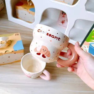 Primer plano de una taza de cerámica croissant bonita con mango grueso y diseño de café genial.