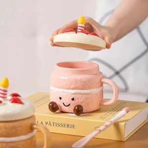 Cute ceramic cake mug detail view, pink coffee cup with candle lid and spoon, lovely gift idea.