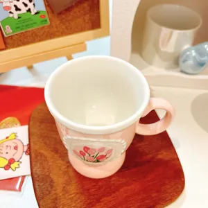 Pink ceramic coffee mug with floral tulip detail, perfect for cozy afternoon tea and home use.