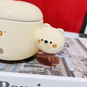 Close-up detail of cute yellow ceramic coffee mug featuring adorable 3d bear handle design.