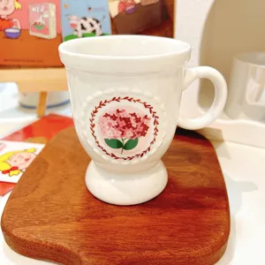 Ceramic coffee mug with floral design and high foot base for daily afternoon tea use.