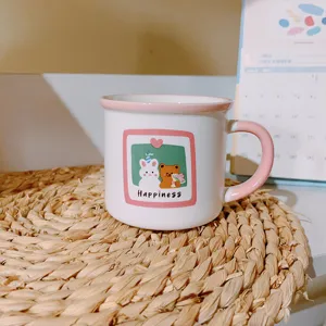 Close-up detail of the cute ceramic coffee mug with cartoon rabbit and bear print, pink handle.