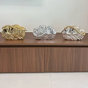 Nahaufnahme der glänzenden metallischen Muschel Abendtasche mit elegantem Perlenhenkel.