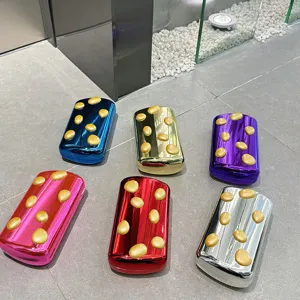 Metallische Bonbon-Farbe Abendtasche Detail mit glänzender Oberfläche und goldenen Punkten.