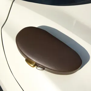 Detailed view of the brown matte shell evening clutch, showcasing unique egg shape and clasp.